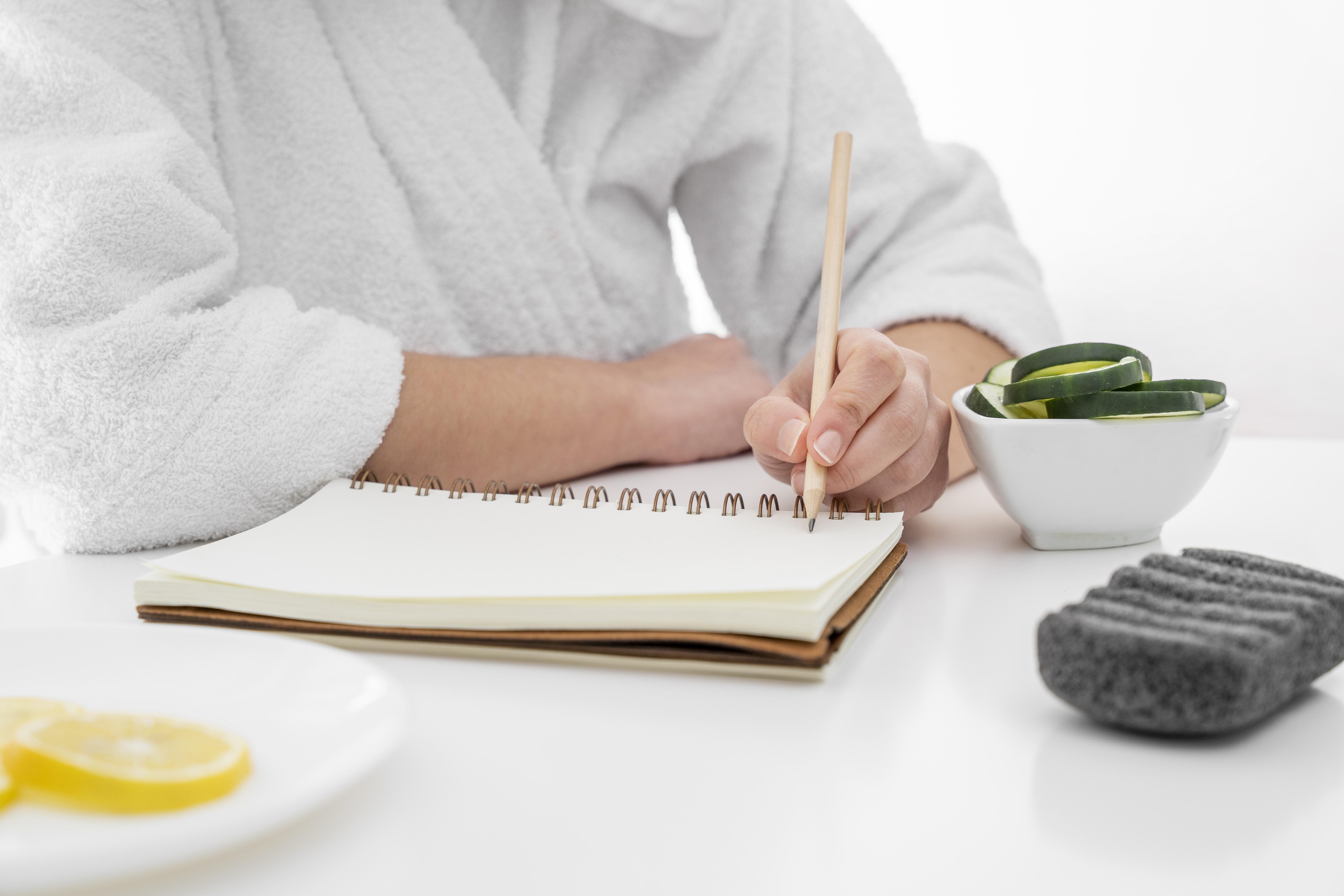 Person writing in a self-care planner or journal